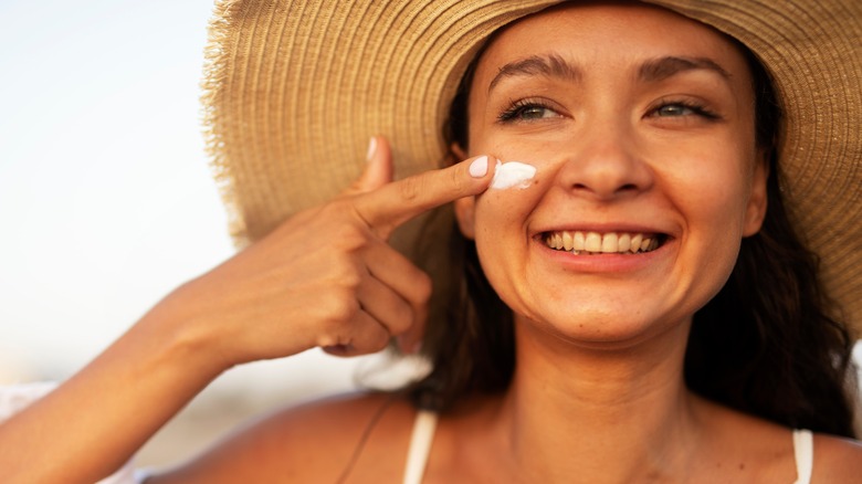 A woman applying sunscreen 