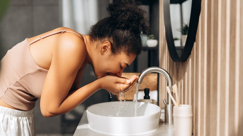 Woman washing her face at the sink