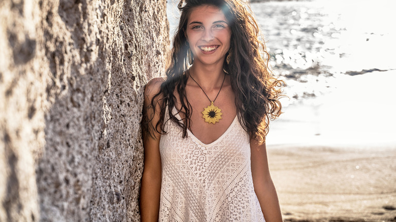 A woman wearing a statement necklace on the beach