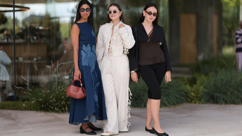 Women pose in sunglasses and summery outfits