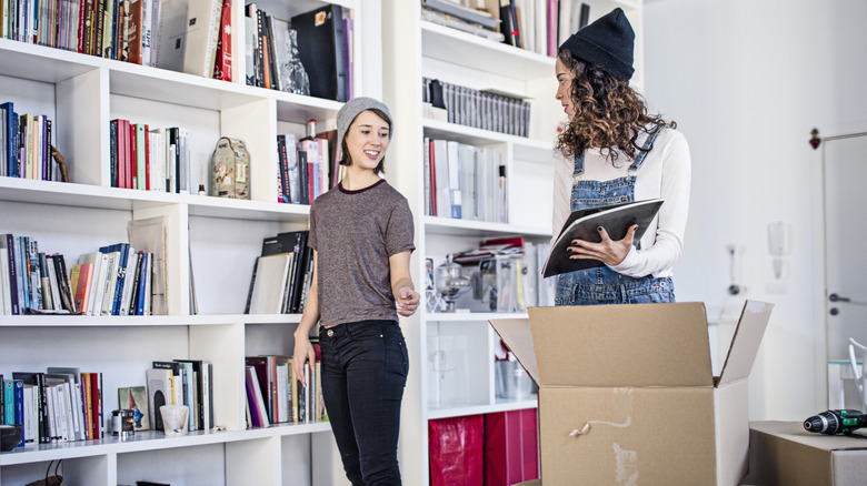 Couple unpacking books onto shelves