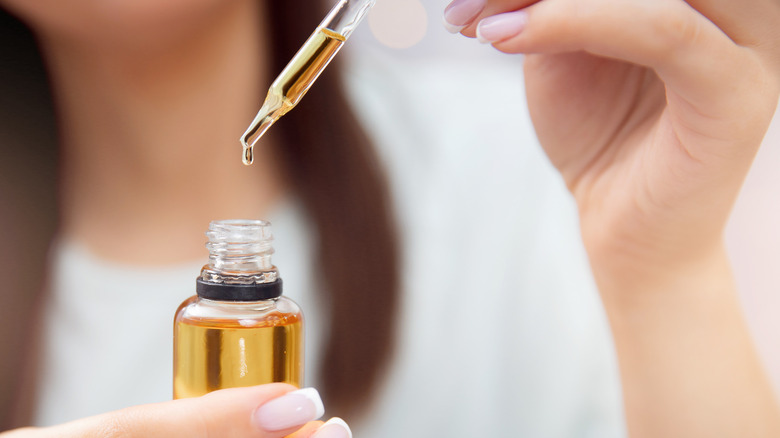 woman applying bronzing drops