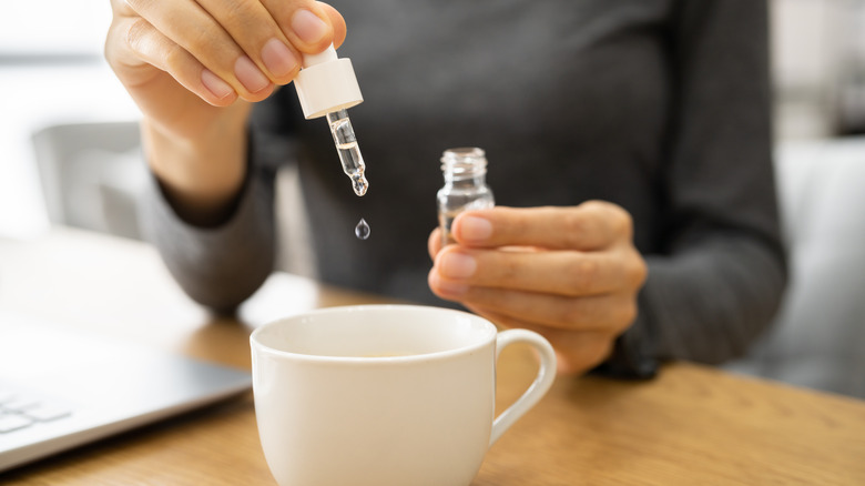 woman pouring tincture in cup