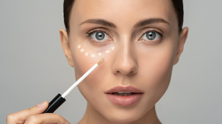 Woman applying concealer