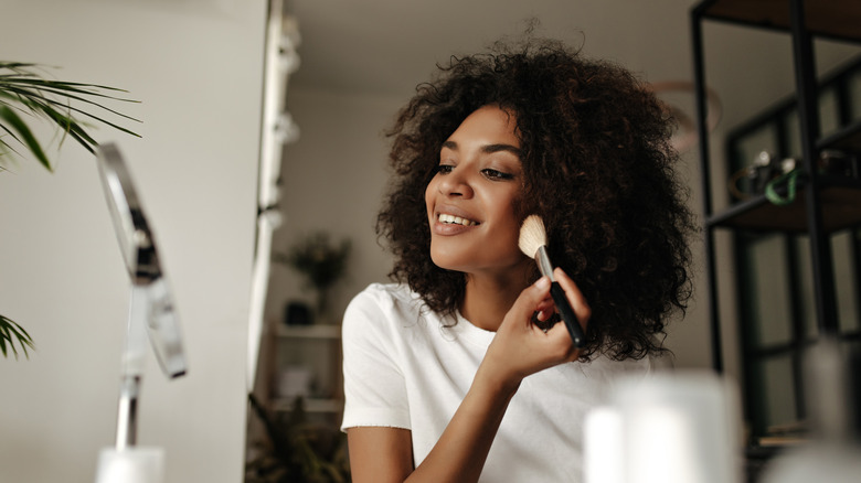 woman applying bronzer with brush
