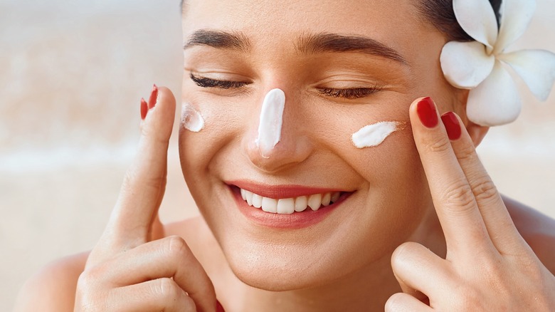 female putting on sunscreen