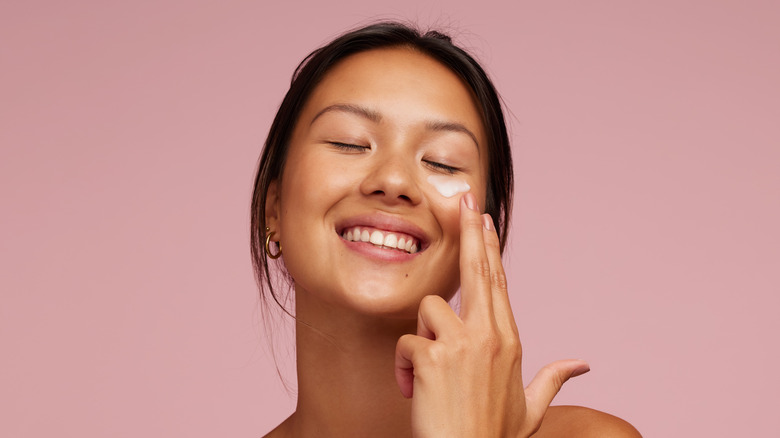 woman applying moisturizer