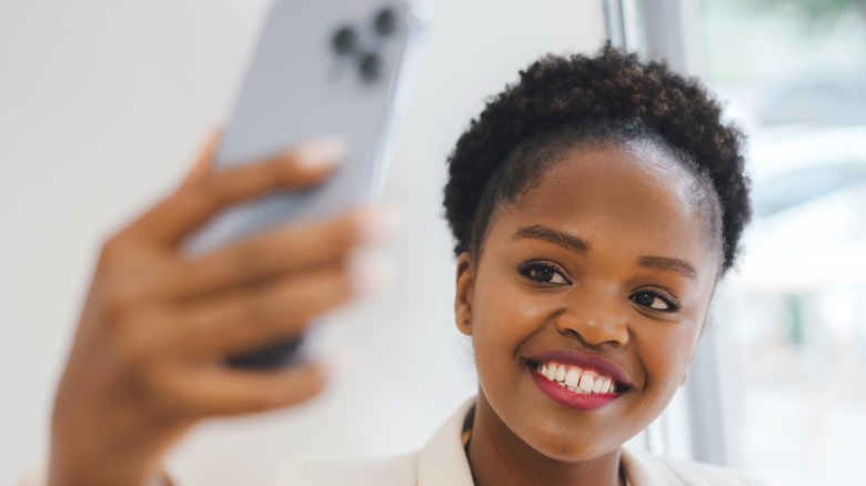 woman taking a selfie near a window