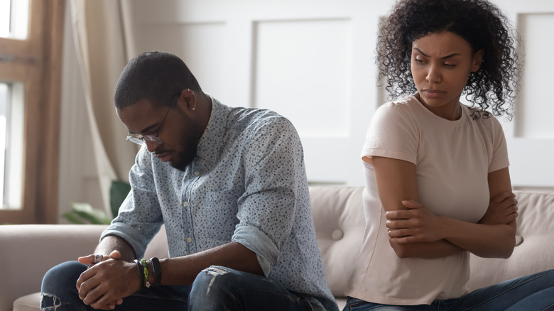 Couple looking upset on couch