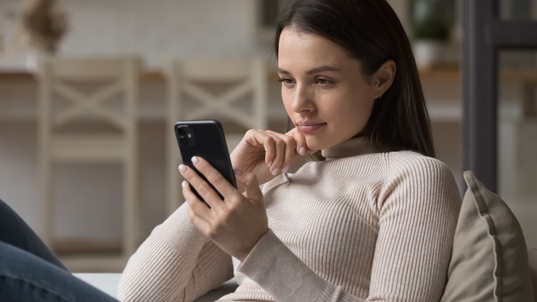 Woman stares into cell phone