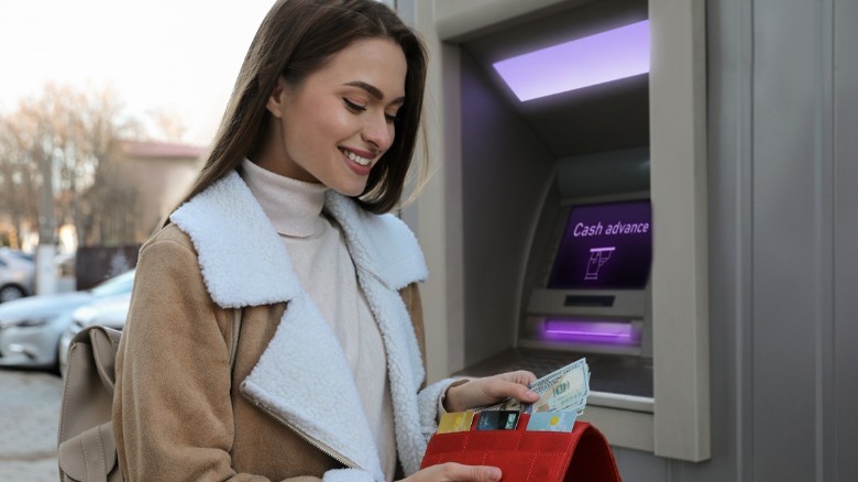 Woman putting money into wallet