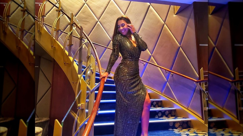 Woman in gold dress posing on cruise ship steps