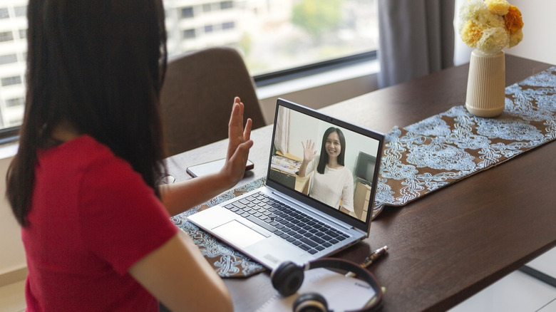 Woman waving to online therapist