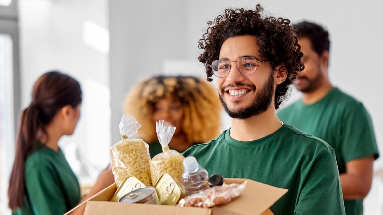 Man holding cardboard box of food