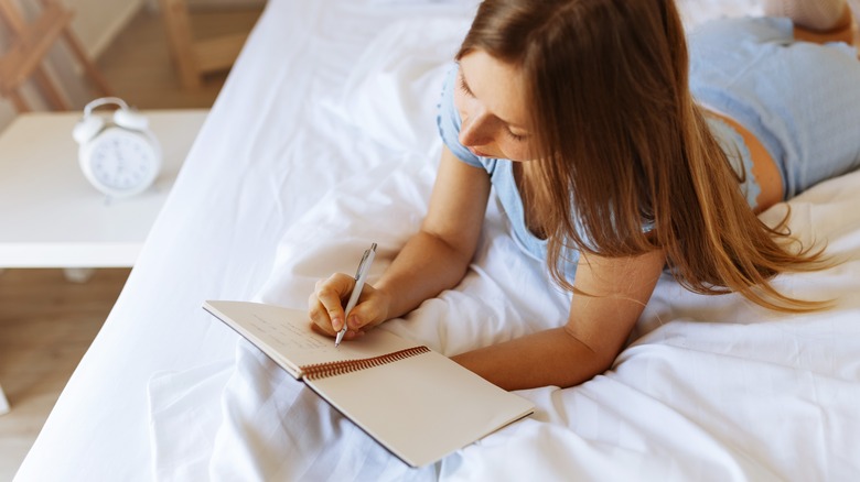 Woman journaling in bed