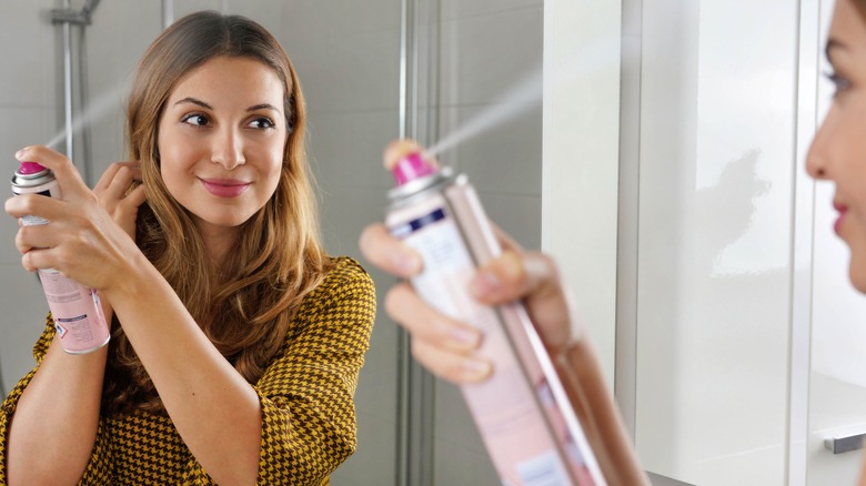 woman applying dry shampoo