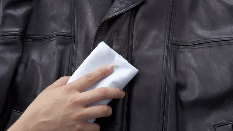 person wiping leather jacket