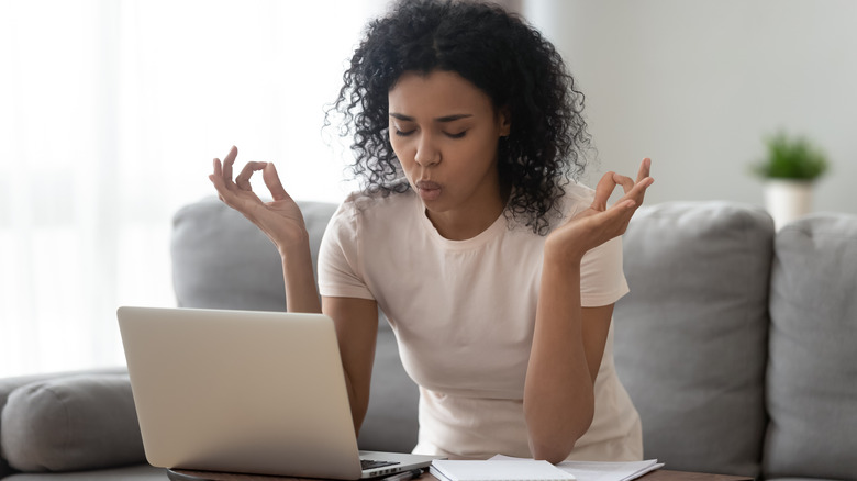 woman meditating at laptop