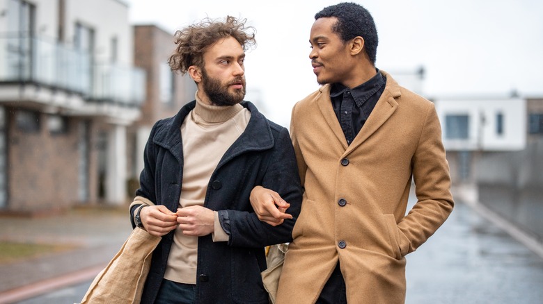 Two men linking arms walking