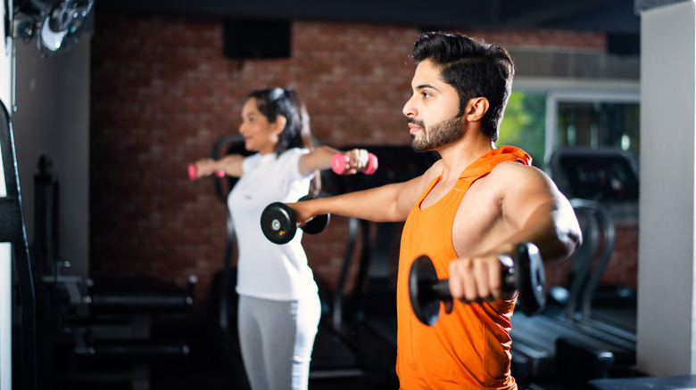 Friends at gym lifting weights