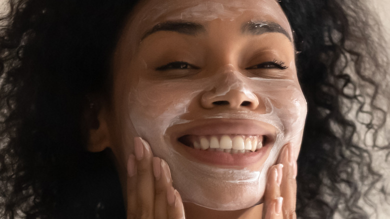 Woman cleansing face