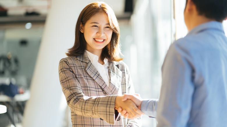 woman shaking person's hand