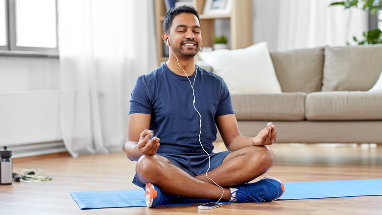 Man meditating on floor
