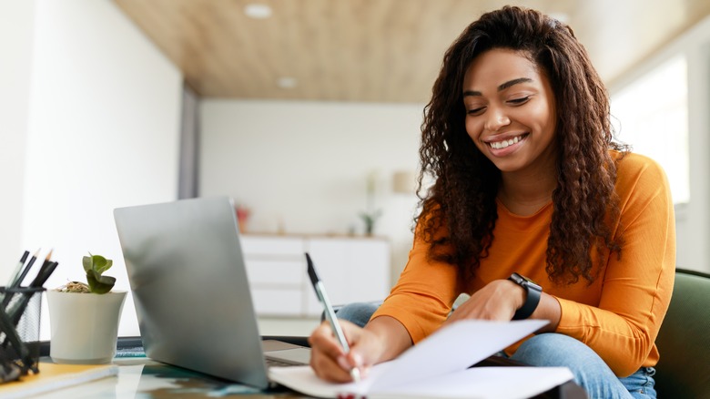 Woman writing notes at desk