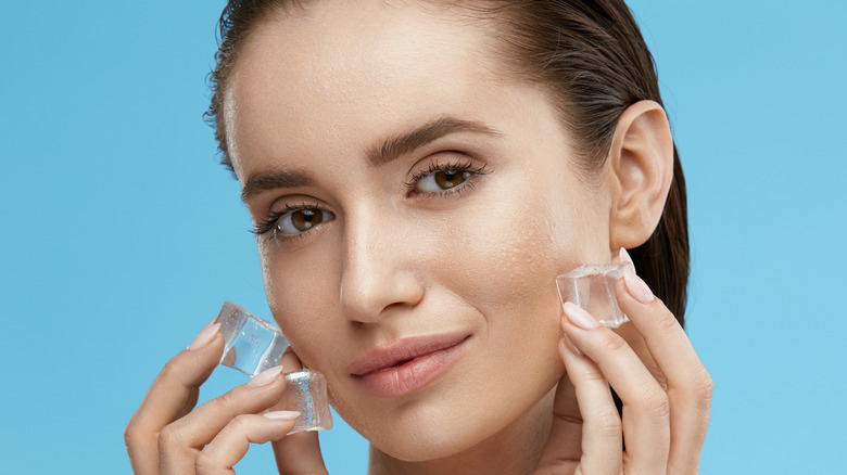 woman holding ice to face