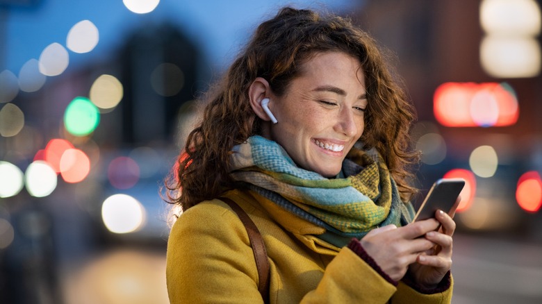 Woman with airpods texting