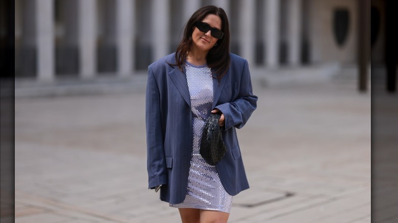 Woman wearing pinstriped blazer, sequined dress
