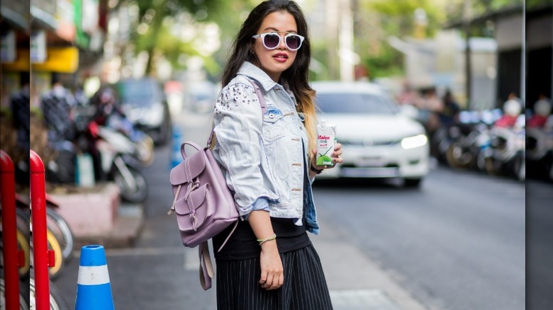 Woman wearing pinstriped pants, denim jacket