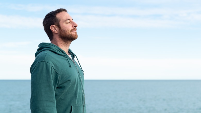 Man standing alone breathing outside
