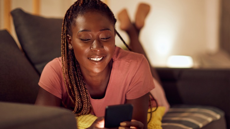 woman texting on couch