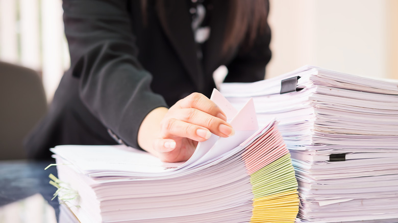 woman holding pile of paper