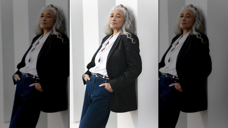 A senior woman in mid-rise jeans, a shirt, and a blazer