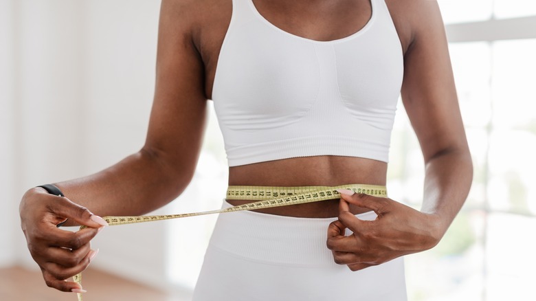 woman measuring waist with tape