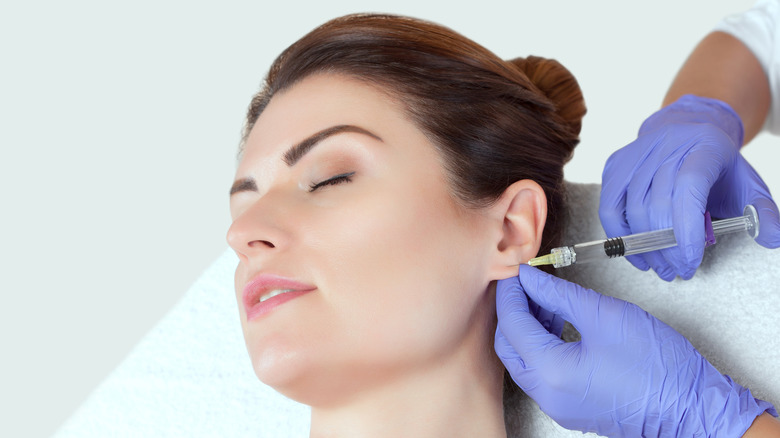 A woman getting earlobe fillers