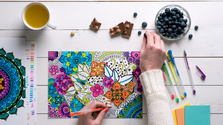 Woman coloring and having snacks
