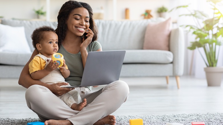 Woman multitasking with work, phone call, and baby
