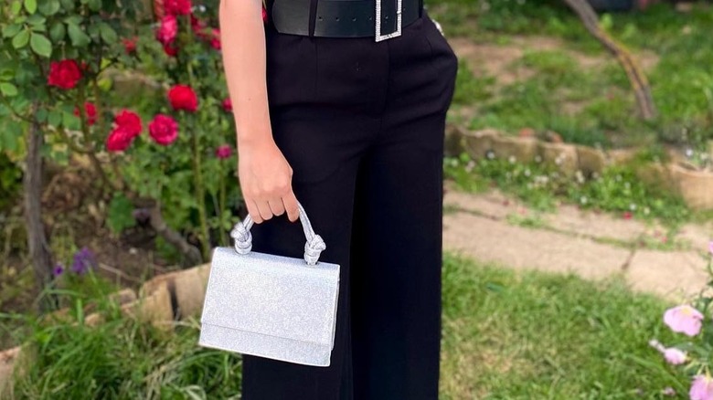 Girl carrying a shiny top handle bag