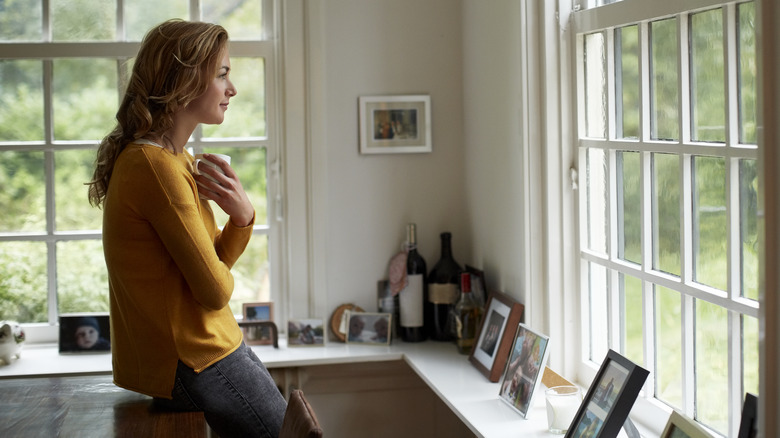 Woman stares out window in thought