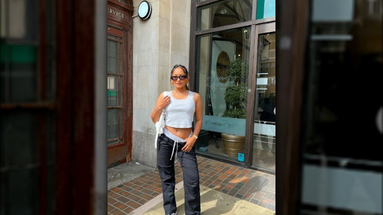 Girl wearing baggy track pants with a tiny top.