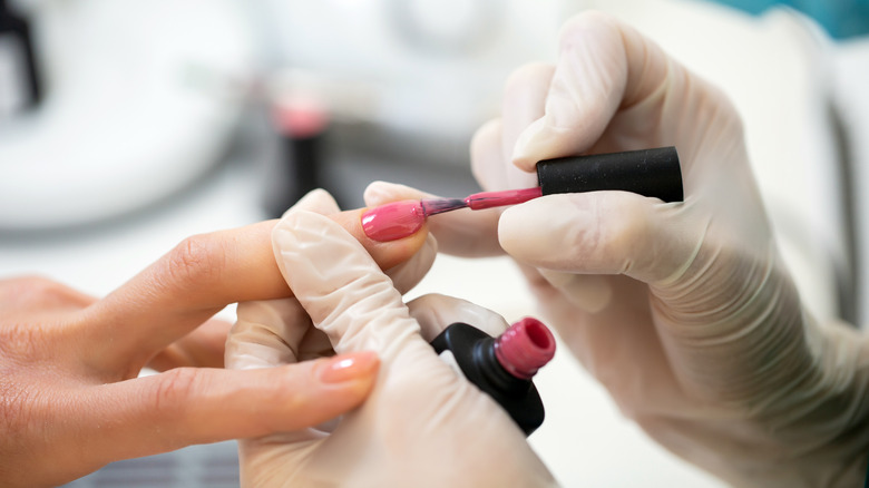 Person painting edge of nail