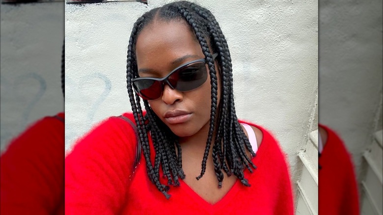Person with a braided lob and sunglasses