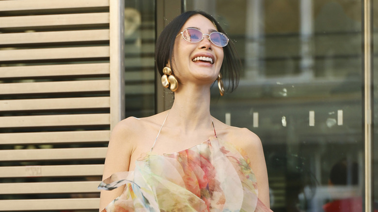 A woman smiles in a floating floral dress
