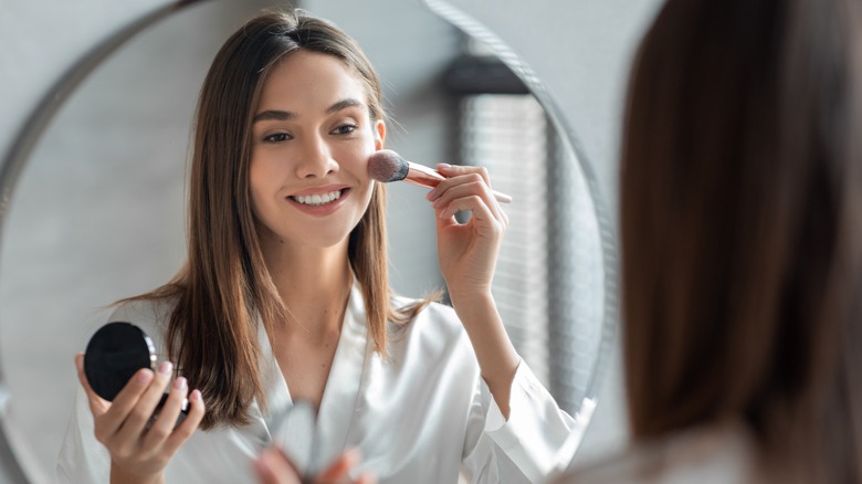A woman applying blush