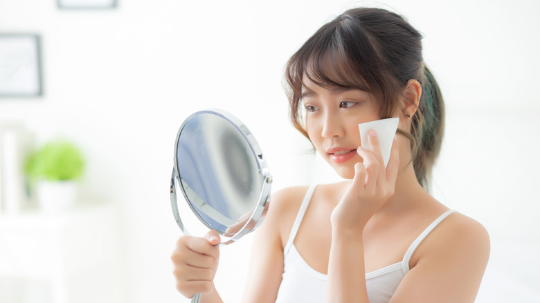 A woman blotting her face
