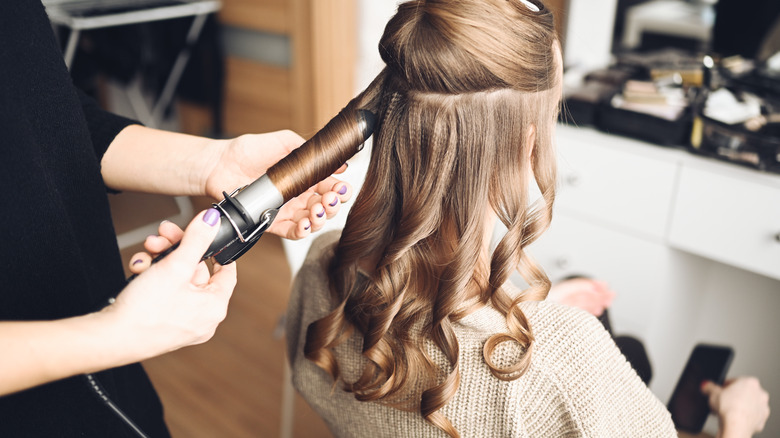 woman using curling iron