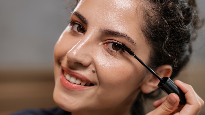 female applying mascara